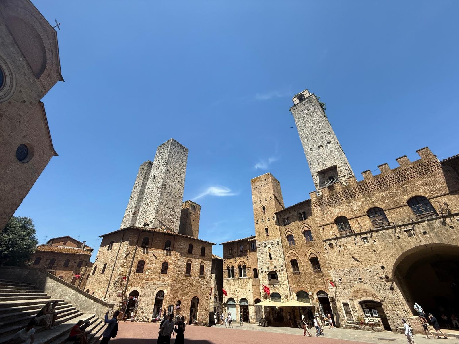 Średniowieczne wieże San Gimignano widziane z placu w słoneczny dzień